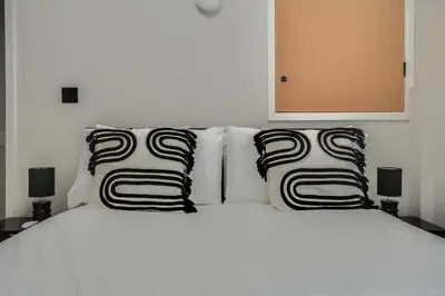 a white bed with black and white pillows on it at Ripon By Serene Stays Stylish Liverpool Home Sleeps 5 with Free Parking Fast WiFi and Close to Stadiums in Liverpool