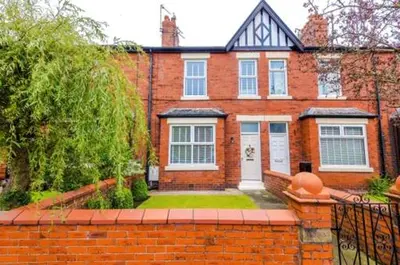 a brick house with a brick fence in front of it at Trent House - Quality 3 Bedroom House Lytham in Brown Moss Side