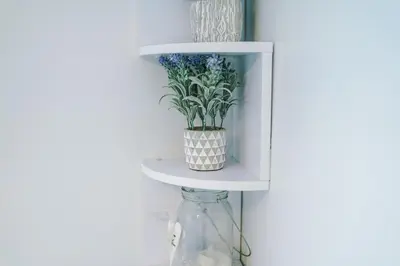 a white shelf with a vase with flowers in it at Trent House - Quality 3 Bedroom House Lytham in Brown Moss Side