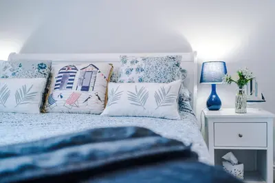 a bedroom with a bed with blue and white pillows at Trent House - Quality 3 Bedroom House Lytham in Brown Moss Side