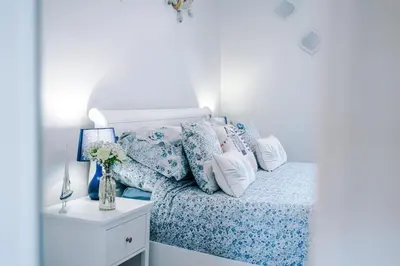 a bed with blue and white sheets and pillows at Trent House - Quality 3 Bedroom House Lytham in Brown Moss Side