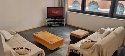 a living room with two couches and a tv at Cable House, Liverpool City Centre in Liverpool