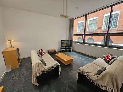 a living room with two couches and a tv at Cable House, Liverpool City Centre in Liverpool