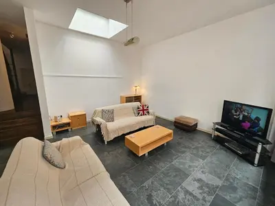 a living room with a couch and a tv at Cable House, Liverpool City Centre in Liverpool