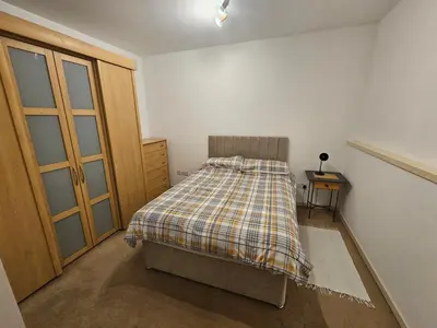 a bedroom with a bed with a plaid blanket on it at Cable House, Liverpool City Centre in Liverpool