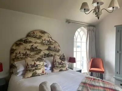 a bedroom with a bed with a floral headboard at The Bothy Cottage in Lytham St Annes
