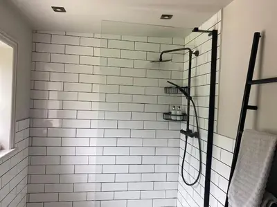 a white tiled shower in a bathroom at The Bothy Cottage in Lytham St Annes