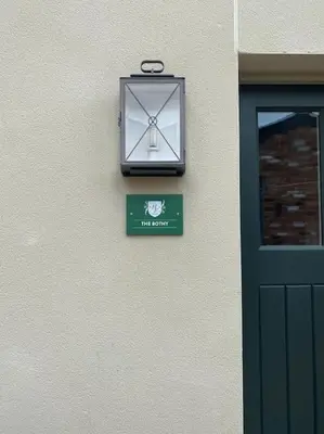 a clock on the side of a building with a sign at The Bothy Cottage in Lytham St Annes