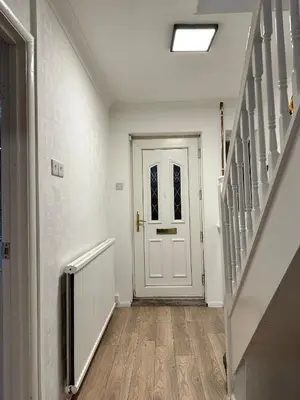 an empty hallway with a white door and stairs at Cozy 3-Bedroom House in Bolton, Huge Garden in Egerton
