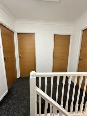 a white staircase with three doors in a room at Cozy 3-Bedroom House in Bolton, Huge Garden in Egerton