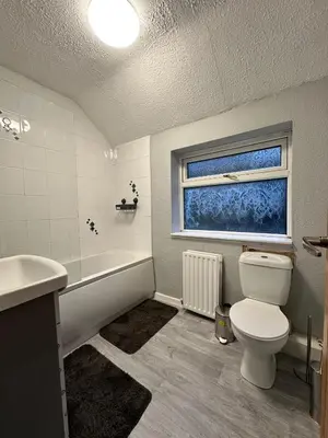 a bathroom with a toilet and a tub and a window at Cozy 3-Bedroom House in Bolton, Huge Garden in Egerton