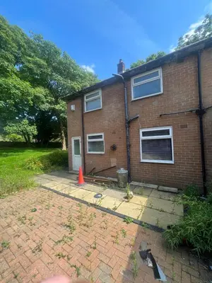 a brick house with a orange cone in front of it at Cozy 3-Bedroom House in Bolton, Huge Garden in Egerton