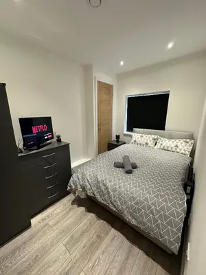 a bedroom with a bed and a flatscreen tv at Luxury rooms Liverpool in Seacombe