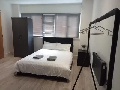 a bedroom with a bed with a black headboard at Luxury rooms Liverpool in Seacombe