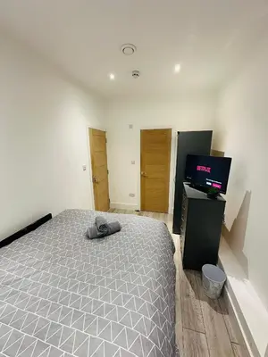 a bedroom with a bed and a flat screen tv at Luxury rooms Liverpool in Seacombe