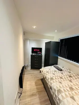 a bedroom with a bed and a flat screen tv at Luxury rooms Liverpool in Seacombe