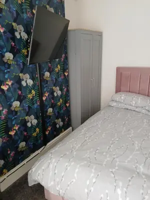 a bedroom with a bed with a floral wallpaper at The White House in Barrow in Furness