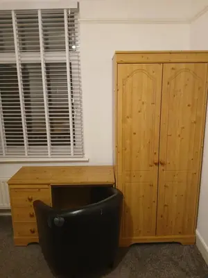 a room with a black chair next to a wooden cabinet at The White House in Barrow in Furness