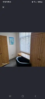 a room with a chair and a desk and a window at The White House in Barrow in Furness