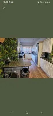 a kitchen with white cabinets and a counter top at The White House in Barrow in Furness