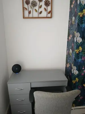 a desk and a chair in a room with a curtain at The White House in Barrow in Furness