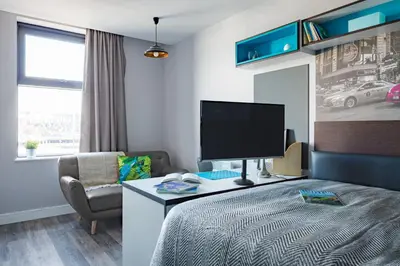 a bedroom with a bed and a tv and a chair at Studio In Central Liverpool, Free Breakfast in Liverpool
