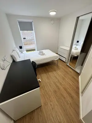 a small room with a bed and a mirror at Cosy Budget En-suites, Optional Kitchen, Liverpool in Liverpool