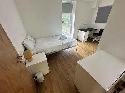 a small white room with a bed and a desk at Cosy Budget En-suites, Optional Kitchen, Liverpool in Liverpool