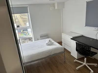 a bedroom with a bed and a desk and a window at Cosy Budget En-suites, Optional Kitchen, Liverpool in Liverpool