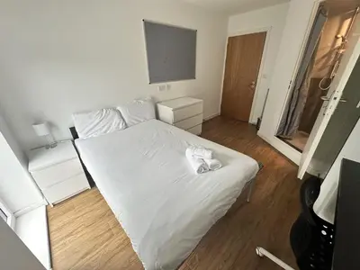 a white bed in a small room with a television at Cosy Budget En-suites, Optional Kitchen, Liverpool in Liverpool