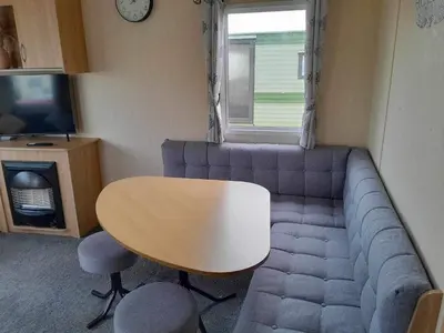 a living room with a couch and a table and a tv at Escape to the bay- arnside escapes in Morecambe
