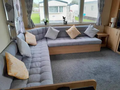 a couch in a living room with a window at Escape to the bay- arnside escapes in Morecambe