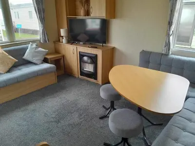 a small living room with a table and a tv at Escape to the bay- arnside escapes in Morecambe
