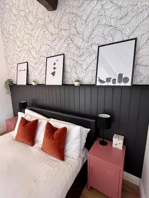 a bedroom with a bed with a black and white wall at Ropewalks City Centre Apartment with Roof Terrace in Liverpool
