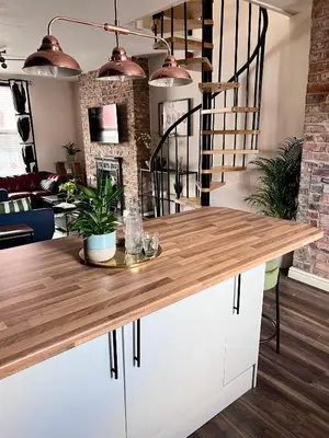 a kitchen with a white island with a wooden counter top at Ropewalks City Centre Apartment with Roof Terrace in Liverpool