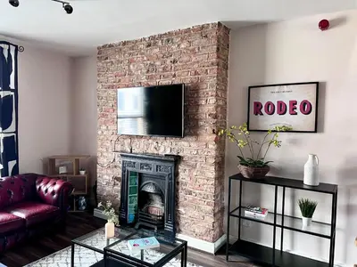 a living room with a brick fireplace with a tv at Ropewalks City Centre Apartment with Roof Terrace in Liverpool