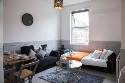 a living room with a couch and a bed at Spacious 2-Bedroom Flat with 4 Beds, Ideal for Contractors, Long Stay Deals in Wallasey
