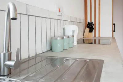 a kitchen counter with three trash cans next to a sink at Spacious 2-Bedroom Flat with 4 Beds, Ideal for Contractors, Long Stay Deals in Wallasey