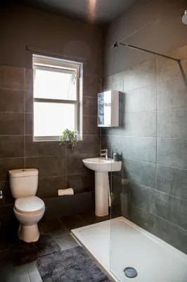 a bathroom with a toilet and a sink and a shower at Spacious 2-Bedroom Flat with 4 Beds, Ideal for Contractors, Long Stay Deals in Wallasey