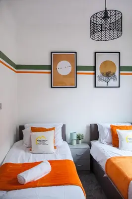 two beds in a room with pictures on the wall at Spacious 2-Bedroom Flat with 4 Beds, Ideal for Contractors, Long Stay Deals in Wallasey