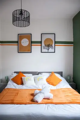 a bedroom with two beds with orange and white pillows at Spacious 2-Bedroom Flat with 4 Beds, Ideal for Contractors, Long Stay Deals in Wallasey