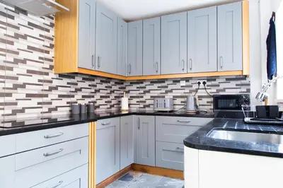 a kitchen with white cabinets and a sink at Eco-Friendly Stay in Barrow-In-Furness, Lake District in Barrow in Furness