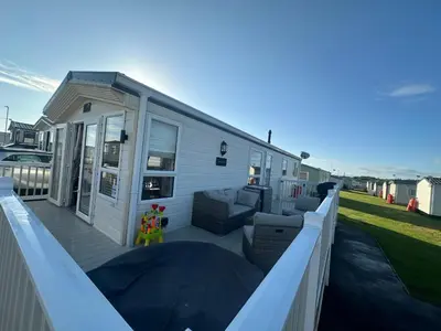 a mobile home with a deck with a couch at Seaside breaks morcambe in Heysham