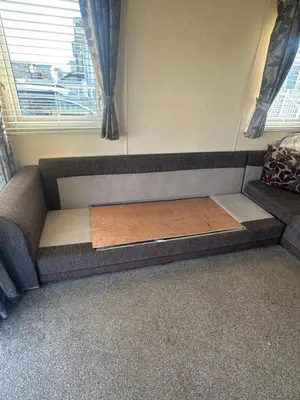 a bed in a room with a couch and a window at Seaside breaks morcambe in Heysham