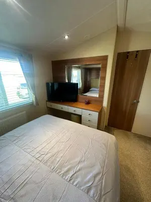 a bedroom with a white bed and a mirror at Seaside breaks morcambe in Heysham