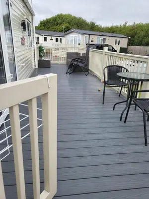 a deck with tables and chairs on a house at Angie stunning holiday home in Heysham