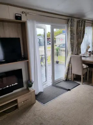 a living room with a television and a sliding glass door at Angie stunning holiday home in Heysham