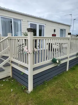 a deck with a white fence and flowers on it at Angie stunning holiday home in Heysham