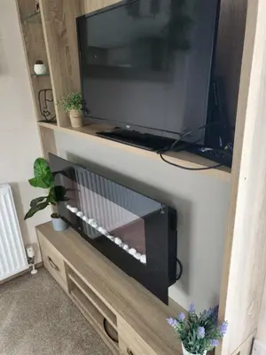 a flat screen tv sitting on top of a entertainment center at Angie stunning holiday home in Heysham