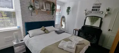 a bedroom with a large bed with towels on it at The Hideaway Cottage Feel Patio Central Parking in Southport